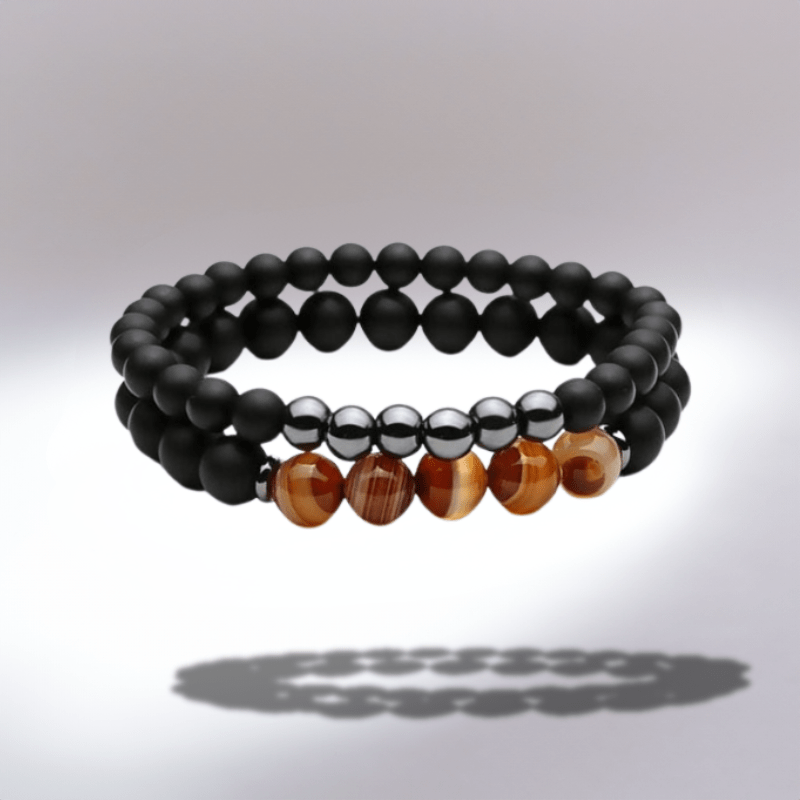 Bracelet en pierres de lave noires avec perles d'agate marron sur fond dégradé